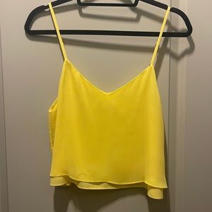 Alice + Olivia cropped, flowy tank top. Color is a vibrant yellow.